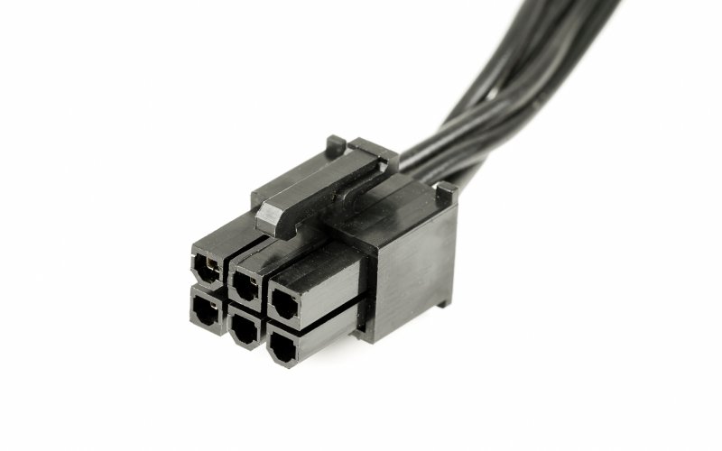 A black six-pin connector with chords coming out of it on a plain, white background.