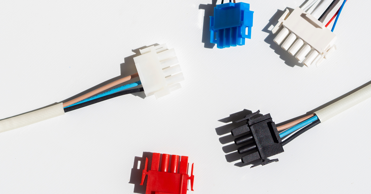 Two white, one blue, one black, and a blue rectangular, multi-pin connectors with wires connected to each one.