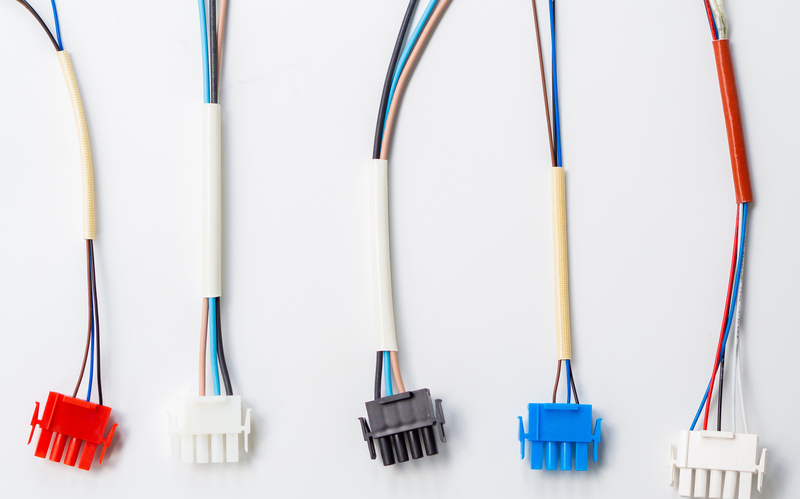 Five connectors with multicolored wires coming out of them laid out vertically on a plain white background.