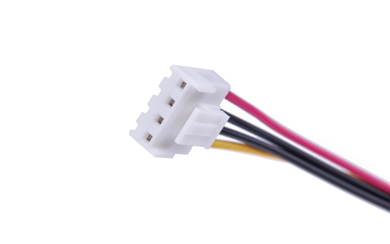 A close-up of a red wire, a yellow wire, and two black wires attached to a white plastic electrical connector.