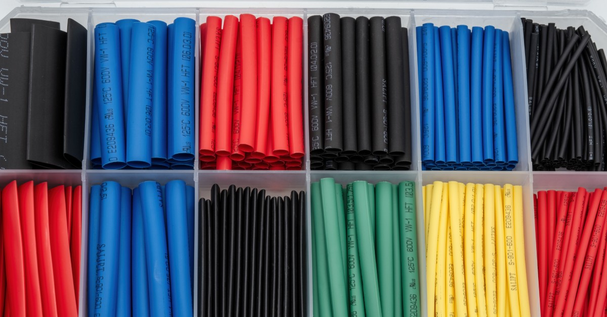 A clear plastic container holds various colors of heat shrink wrapping for electrical wires in separate compartments.